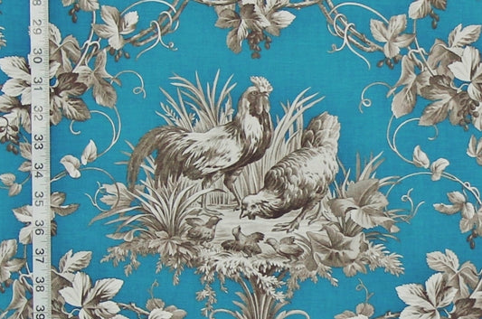 A close-up of a fabric pattern featuring two roosters and a chick among grapevines and leaves on a bright turquoise blue background, with a white measuring tape visible along the left edge.