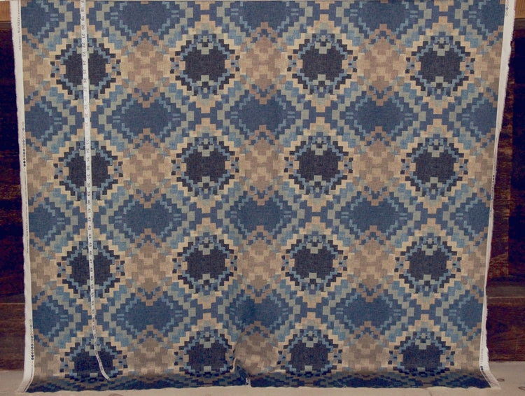 Textile with blue and beige diamond pattern on a wooden background
