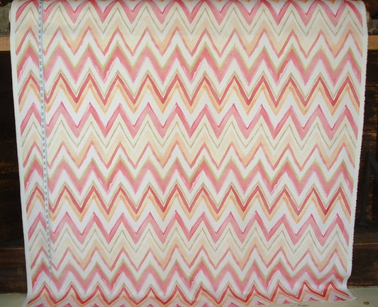 Chevron patterned fabric with pink and orange colors on a wooden background