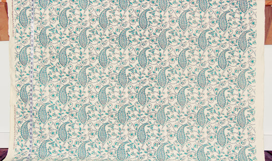 Patterned fabric with green paisley design on a beige background