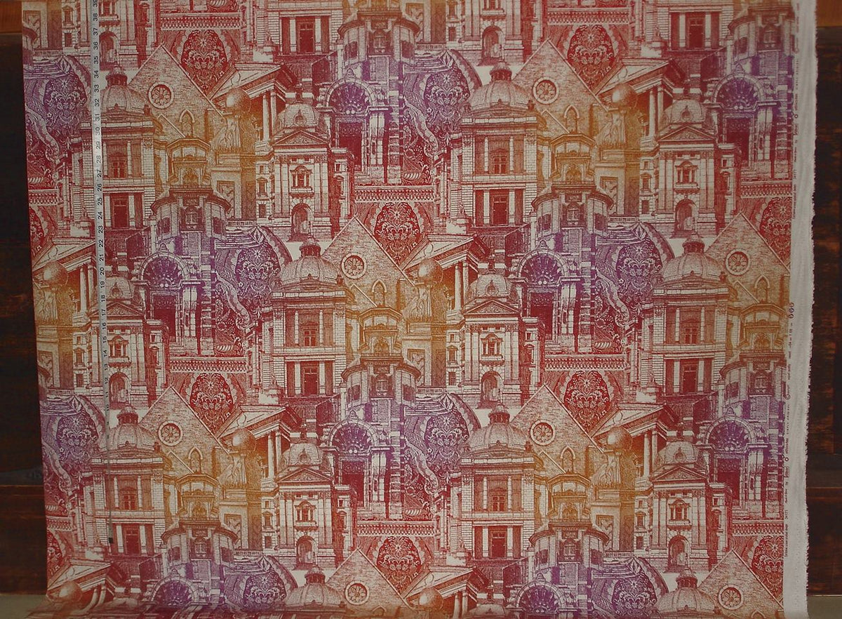 Textile with a pattern of small buildings in various colors on a wooden surface