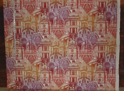 Textile with a pattern of small buildings in various colors on a wooden surface