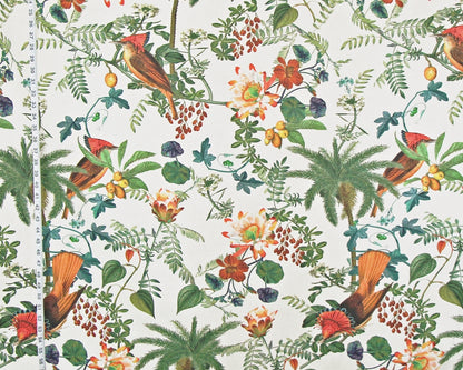 A close-up of a fabric or wallpaper pattern featuring a classic botanical and bird design. The print shows red-tailed birds, palm trees, berries, and flowers on a cream-colored background, with a white measuring tape visible on the left side to indicate scale.
