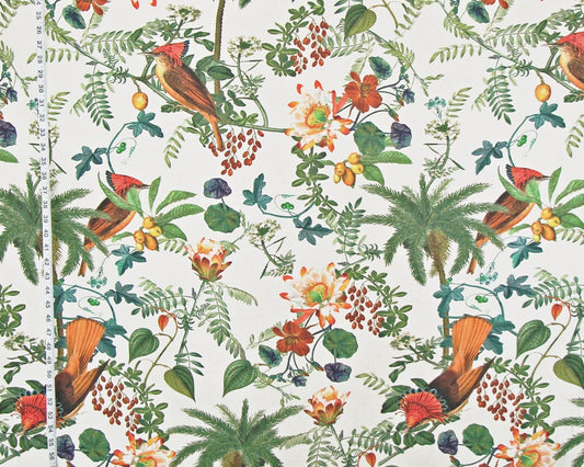 A close-up of a fabric or wallpaper pattern featuring a classic botanical and bird design. The print shows red-tailed birds, palm trees, berries, and flowers on a cream-colored background, with a white measuring tape visible on the left side to indicate scale.