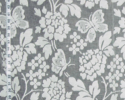 Gray and white floral fabric with butterflies and a measuring tape visible along the left edge.