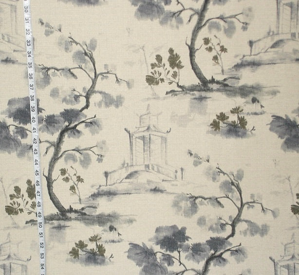 Fabric with a scenic print featuring trees and a building, measured against a ruler.
