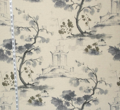 Fabric with a scenic print featuring trees and a building, measured against a ruler.