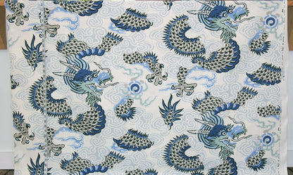 Fabric with blue and green dragon pattern on a light background