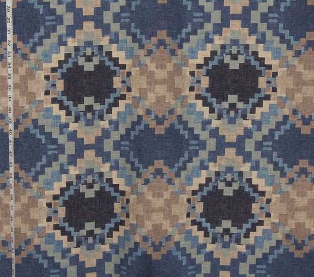 Patterned fabric with geometric design in blue and brown tones, shown with a ruler for scale.