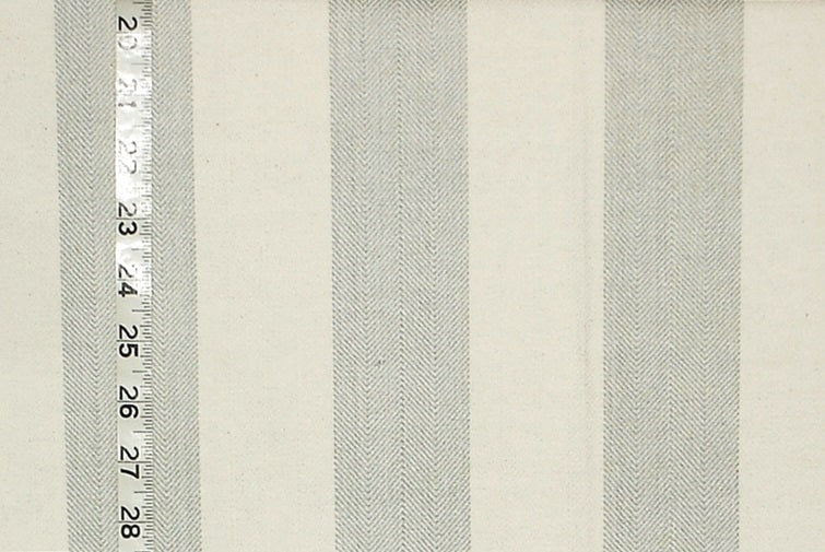 Textured fabric with horizontal stripes and a ruler for scale on a beige background