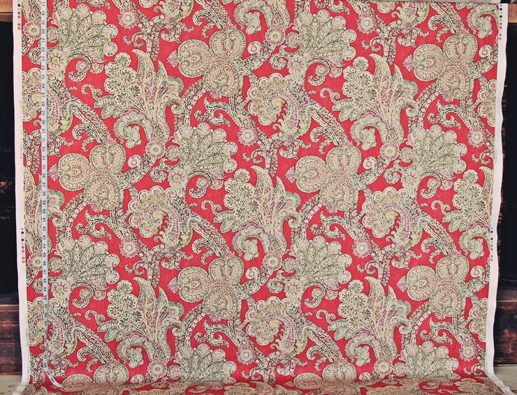 Red fabric with intricate beige floral patterns