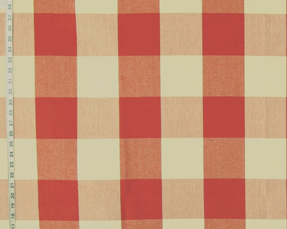 A close-up of a gingham checkered fabric pattern with alternating red and warm beige squares, shown with a measurement ruler along the left edge.