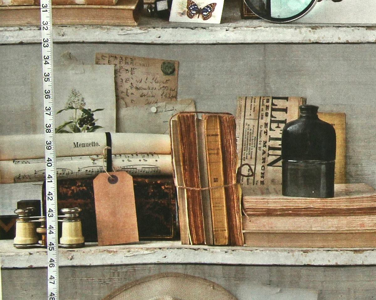 A styled vintage shelf scene with old books, a black bottle, small glass bottles, a wooden tag, and handwritten papers on a weathered gray shelf. A vertical measuring tape is visible along the left side, suggesting a scale or decor reference.