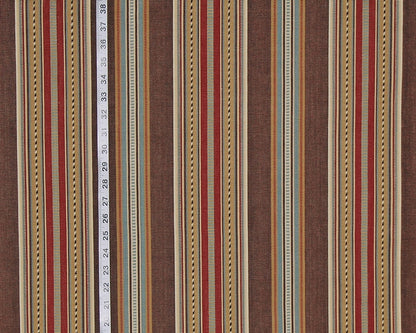 A close-up of a striped fabric pattern with vertical bands in brown, rust red, beige, and muted blue, with a white measuring tape running down the center to indicate scale.