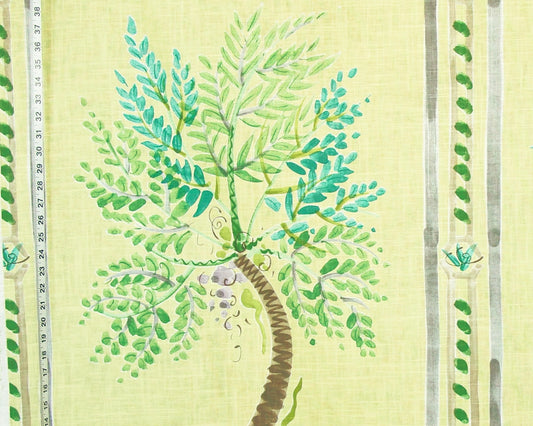 A close-up of a fabric or wallpaper pattern featuring a painted green palm tree on a pale yellow background, with vertical decorative stripes and small leaf motifs along the sides.