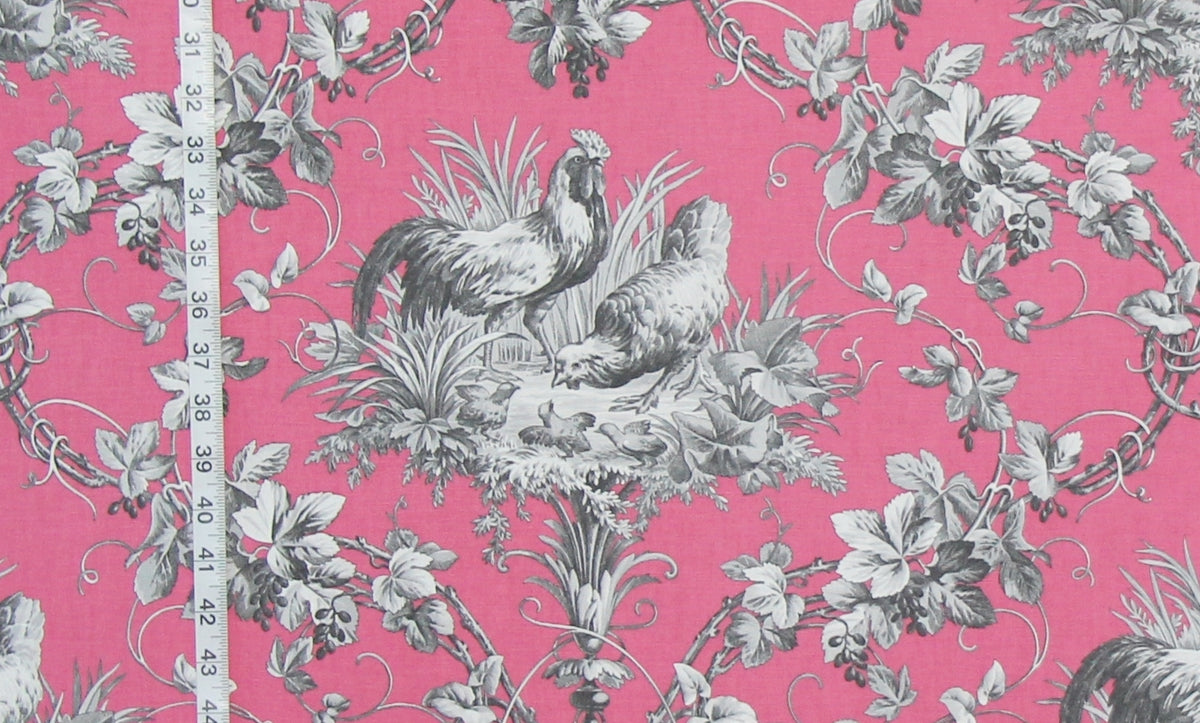 Pink fabric with a classic French Toile pattern featuring gray roosters, chickens, grapes, and leaves, shown with a white measuring tape on the left side.