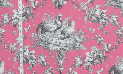 Pink fabric with a classic French Toile pattern featuring gray roosters, chickens, grapes, and leaves, shown with a white measuring tape on the left side.