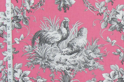 Pink fabric with a classic French Toile pattern featuring gray and black illustrations of a rooster, hen, ducks, and climbing vines, shown with a white ruler on the left edge for scale.