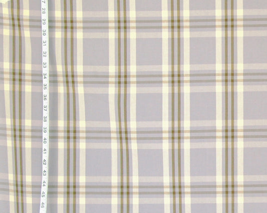 A close-up of a plaid fabric pattern with a light gray base, cream stripes, and muted olive green lines, with a vertical ruler on the left side showing measurement markings.