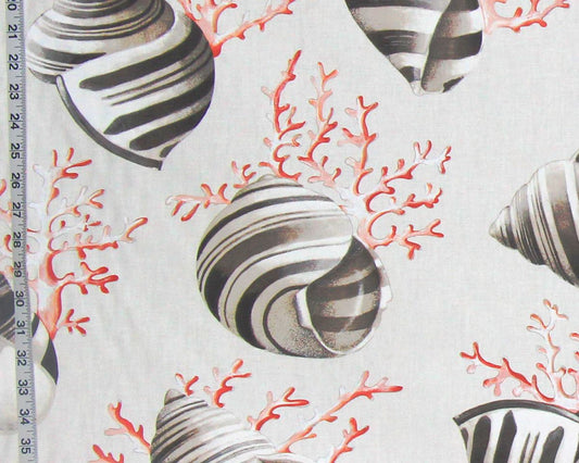 A close-up of a fabric pattern featuring black and white striped seashells and coral in red-orange on a light beige background, with a measuring ruler visible along the left edge.