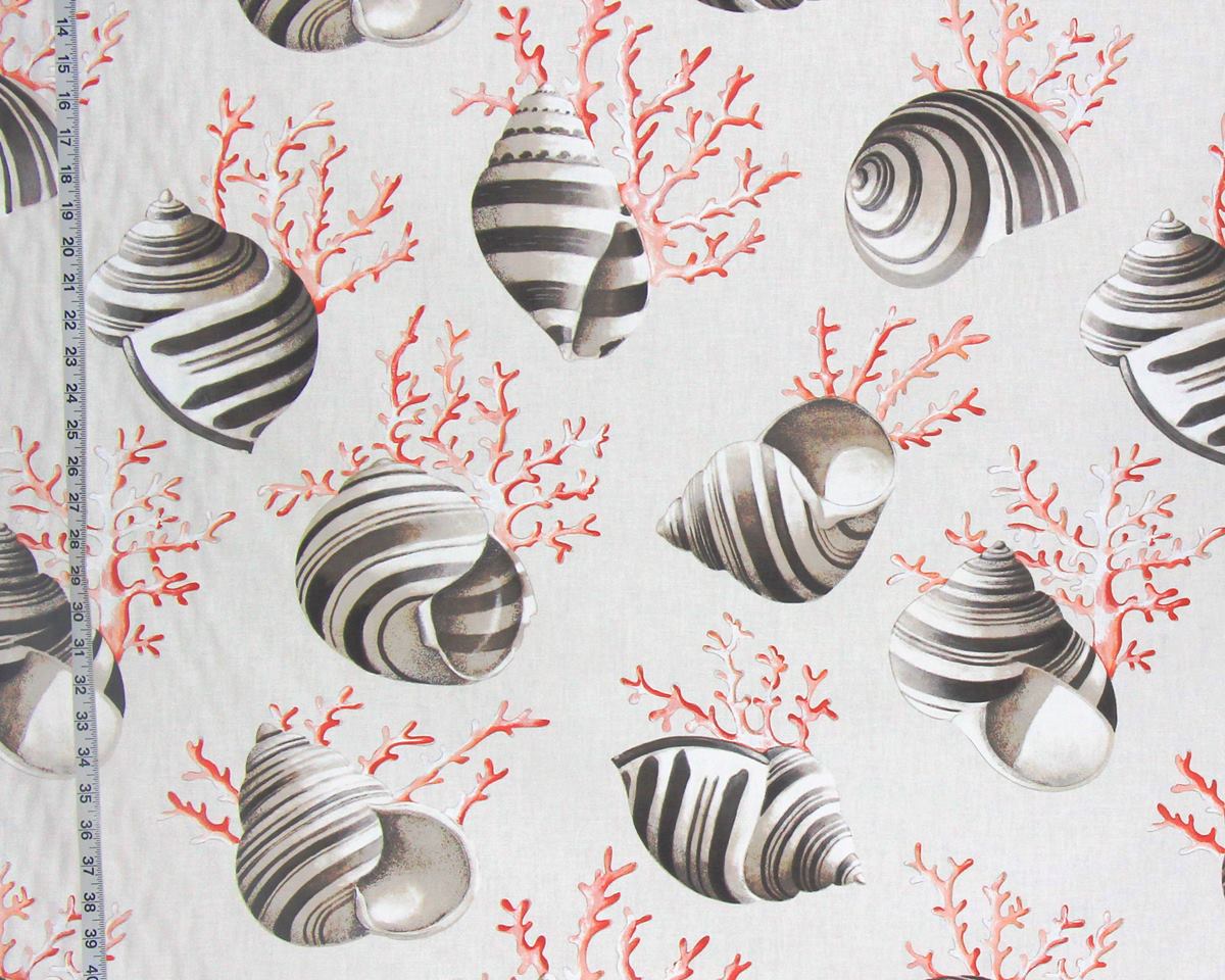 A close-up of a fabric or wallpaper pattern featuring realistic striped seashells and coral branches in coral red and gray on a warm off-white background. A measuring tape is visible along the left edge to indicate scale.