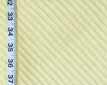 Close-up of a pale yellow ribbed fabric texture with a white measuring ruler along the left edge for scale.