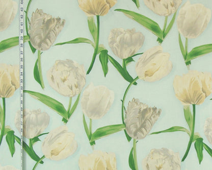 A close-up of a floral patterned surface featuring cream and off-white tulips with green stems and leaves on a pale mint background, with a measuring tape visible along the left edge.