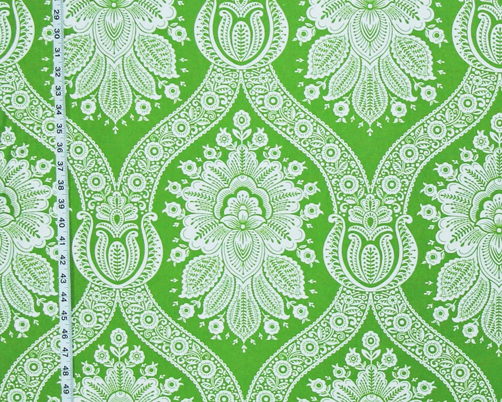 Green and white damask patterned fabric with a vertical measuring tape visible on the left side.
