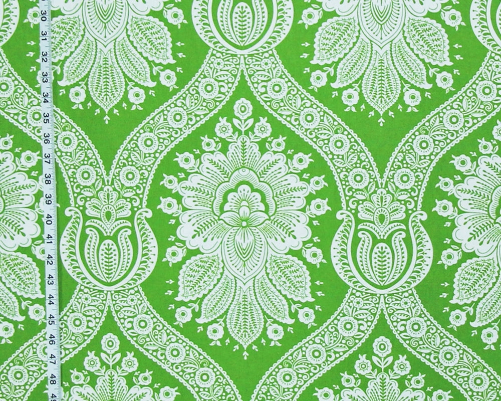 Green and white damask patterned fabric shown with a measuring tape on the left side for scale.