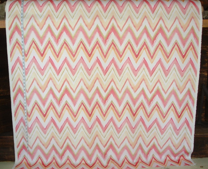 Chevron patterned fabric with pink and orange colors on a wooden background