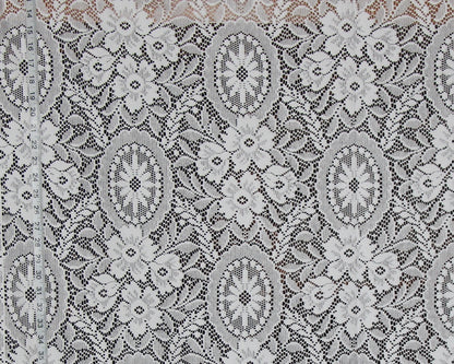 White floral lace fabric with intricate embroidered patterns and a ruler visible on the left side for scale.