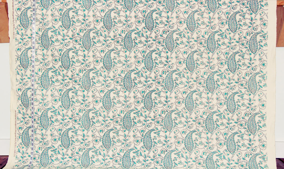 Patterned fabric with green paisley design on a beige background
