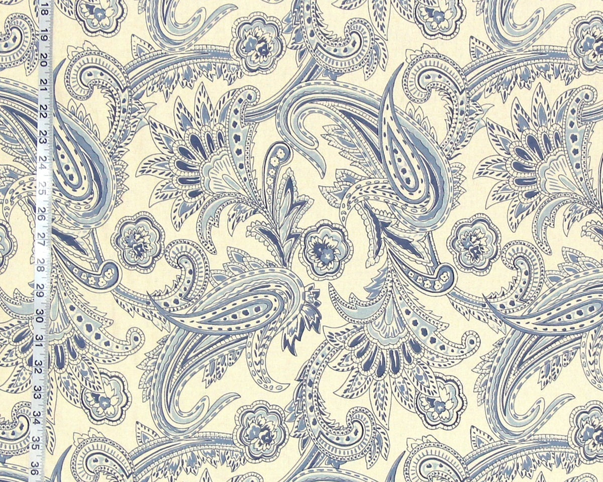Blue paisley pattern on a beige background with a ruler for scale.
