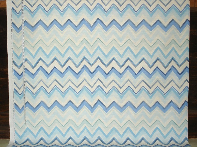 Fabric with blue and white zigzag pattern on a wooden background